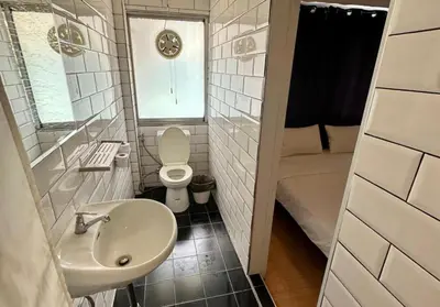 a bathroom with a sink and a toilet and a shower at The Cute Silom hostel in Bangkok