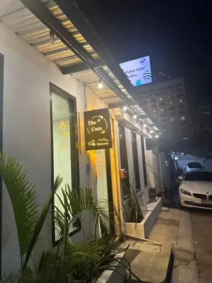 a sign on the side of a building at night at The Cute Silom hostel in Bangkok