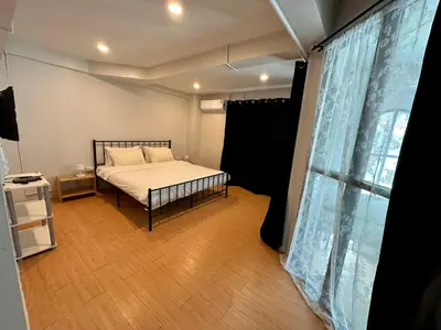 a bedroom with a bed and a large window at The Cute Silom hostel in Bangkok