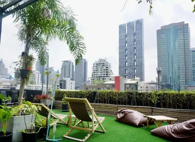 a patio with chairs and plants in a city at Hash Silom Apartment @ Silom Soi 3 in Bangkok