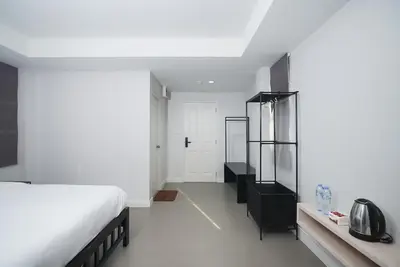 a bedroom with a white bed and a black cabinet at xx Mitr Inn The Grand Palace Samyot - มิตร อินน์ พระบรมมหาราชวัง Pro in Bangkok