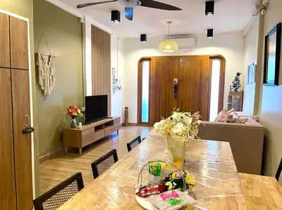 a living room with a long wooden table with chairs at Private house with Pagoda view, near Grand Palace in Bangkok