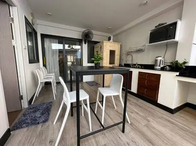 a kitchen with a black table and white chairs at Cozy home @ Chatcuchak/中文服务 in Bang O