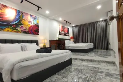 a bedroom with two beds and a painting on the wall at Cozy home @ Chatcuchak/中文服务 in Bang O