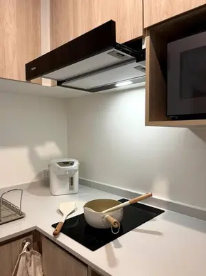 a kitchen with a pan and spatulas on a stove at Nue Z-Square Suan Luang Station - Cozy 2BR Condo, Pool&Gym, Near Suan Luang Station in Bangna