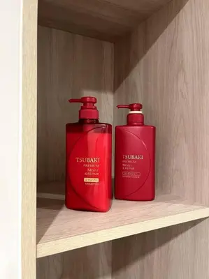 two red bottles are sitting on a shelf at Nue Z-Square Suan Luang Station - Cozy 2BR Condo, Pool&Gym, Near Suan Luang Station in Bangna