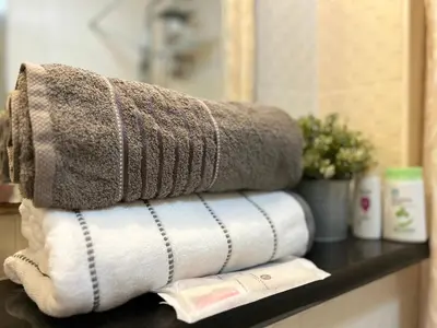 a stack of towels on a shelf in a bathroom at Cozy Victoria Lakeview 5 mins to Impact Muang Thong in Ban Bang Phang