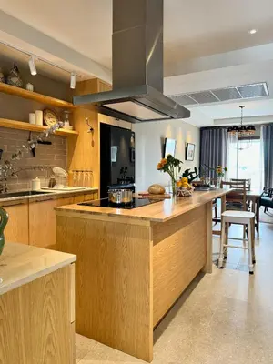 a large kitchen with wooden cabinets and a kitchen island at Brown's Residence in Bangkok