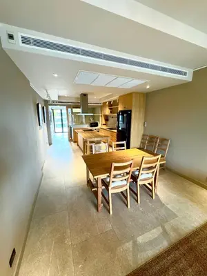 a dining room with a wooden table and chairs at Brown's Residence in Bangkok