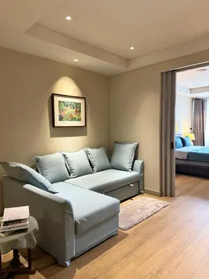 a living room with a couch and a bed at Brown's Residence in Bangkok