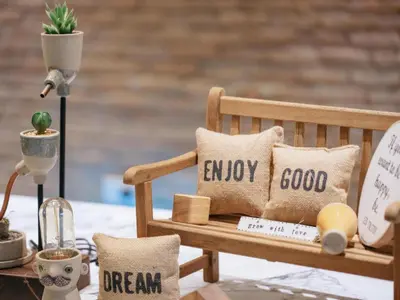 a wooden bench sitting on top of a table with pillows at Clef Hotel Bangkok in Ban Khlong Samrong