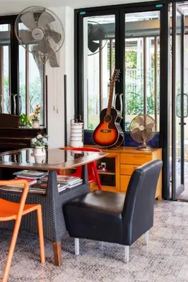 a living room with a table and a guitar on a desk at BB House Mini Suite Hotel in Ban Zong Katiam
