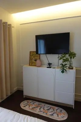 a living room with a flat screen tv on a white cabinet at AboutTime Bangkok in Bangkok