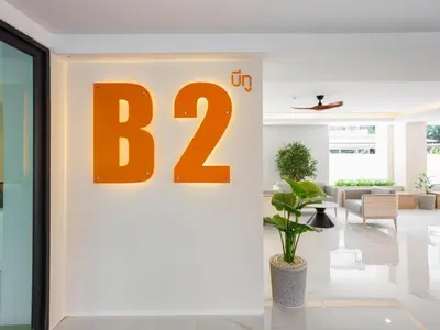 a large orange sign on a wall in a lobby at B2 Huai Khwang Boutique & Budget Hotel in Bangkok