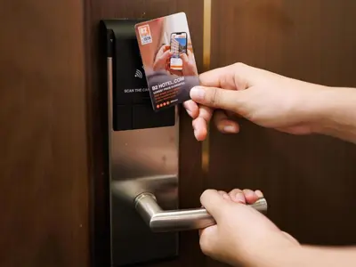a person holding up a card to unlock a door at B2 Huai Khwang Boutique & Budget Hotel in Bangkok
