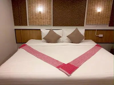 a large bed with a red and white blanket at THOUSAND-TEN THOUSAND HOTEL in Sathani Wat Sing