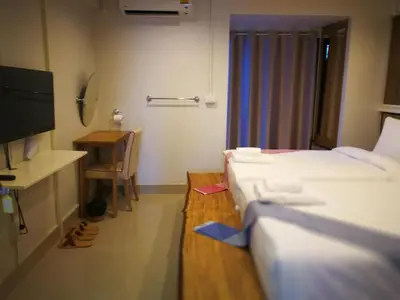 a small room with two beds and a television at THOUSAND-TEN THOUSAND HOTEL in Sathani Wat Sing