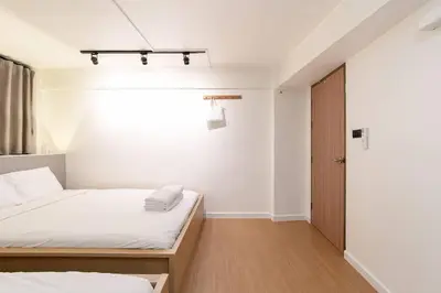 a bedroom with two beds and a closet at Townhouse in Pratunam Bangkok in Bangkok
