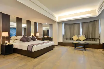 a large bedroom with a bed and a desk and a table at The Grand Sathorn in Bangkok