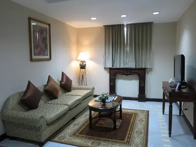 a living room with a couch and a television at The Grand Sathorn in Bangkok