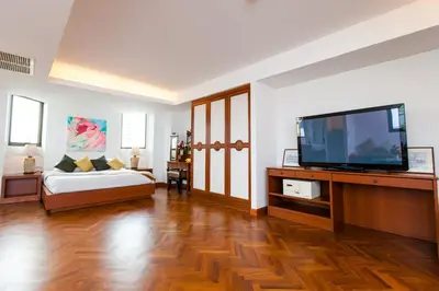 a living room with a bed and a flat screen tv at The Grand Sathorn in Bangkok