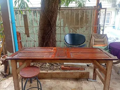 a wooden table sitting in front of a tree at Best Guest Bangkok in Bangkok