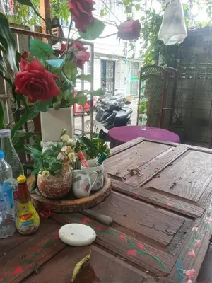 a wooden table with a flower arrangement on top of it at GN GOOD NICE in Bangkok