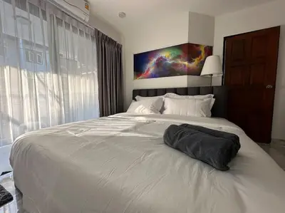 a bedroom with a white bed with a pillow on it at Private cozy house @Chatcuchak in Bang O