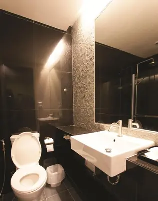a bathroom with a white toilet and a sink at Varrzon Residence Srinakarin 56 in Bangna