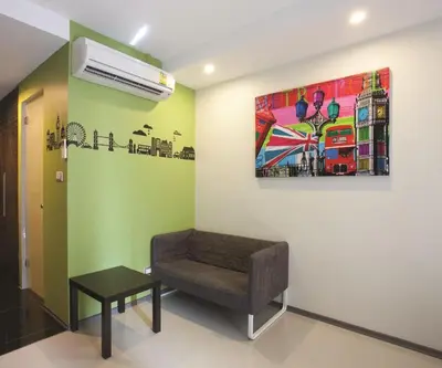 a room with a chair and a painting on the wall at Varrzon Residence Srinakarin 56 in Bangna