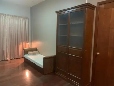 a room with a cabinet and a chair in it at Tanwa Suite - MRT Ratchadapisek in Bangkok