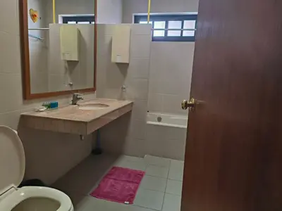a bathroom with a sink and a toilet and a mirror at Tanwa Suite - MRT Ratchadapisek in Bangkok