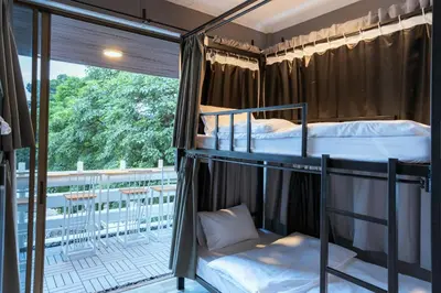 two bunk beds in a room with a balcony at 420 Hostel - Ekkamai Buds & Beds in Bangkok