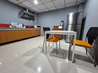 a kitchen with a table and chairs and a refrigerator at Bangkok vibe, City House, 7 mins to BTS, City center, Private room in Sathon, Private bathroom, Bangkok, Thailand in Bangkok
