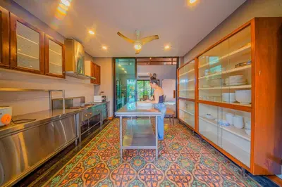 a person standing in a kitchen with a sink at 189summer villa曼谷中心Asok&Thong Lor顶级豪宅庄园泳池别墅 in Bangkok