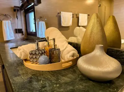 a bathroom with a counter with towels and vases on it at 1897summer villa 曼谷中心7卧Asok&Thong Lor800平米海天别墅 in Bangkok