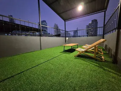 a bench on a balcony with a view of the city at Phuket vibe, City House, 7 mins to BTS, City center, Private room in Sathon, Private bathroom, Bangkok, Thailand in Bangkok