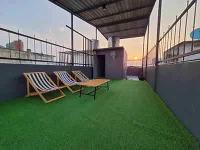 two chairs and a table on a balcony with green grass at Phuket vibe, City House, 7 mins to BTS, City center, Private room in Sathon, Private bathroom, Bangkok, Thailand in Bangkok