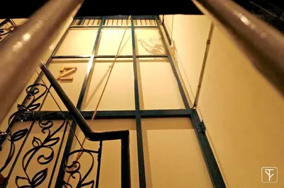 a clock in a room with a window at T-Boutique Hostel - Hua Lamphong in Bangkok