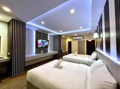 a hotel room with two beds and a flat screen tv at DiscoveryHome5 at Pratunammarket in Bangkok