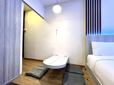 a small room with a bed and a white table at DiscoveryHome5 at Pratunammarket in Bangkok