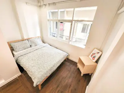 a small bedroom with a bed and a window at Cooper in Bangkok