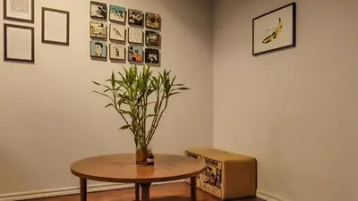 a room with a table and a vase with a plant at Cooper in Bangkok