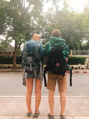 two people with backpacks standing on a street at Cooper in Bangkok