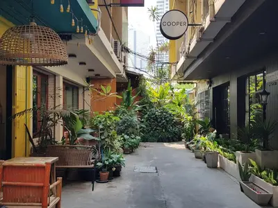 an alley with a bunch of potted plants in a building at Cooper in Bangkok