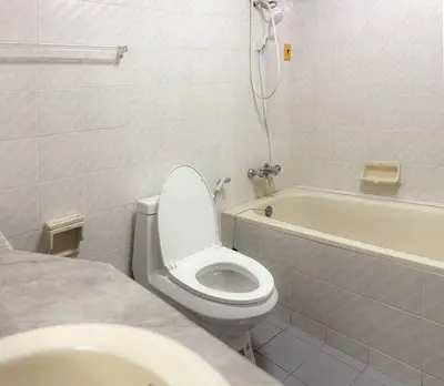 a white bathroom with a toilet and a bath tub at Private House 3 Suite Beds + Double Beds in Heart of Phromphong in Bangkok