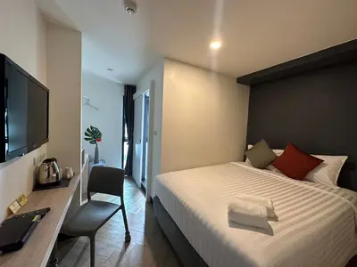 a bedroom with a bed and a desk and a television at 14 Sathorn Hotel in Bangkok