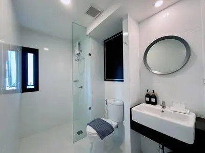 a bathroom with a toilet and a sink and a mirror at 14 Sathorn Hotel in Bangkok