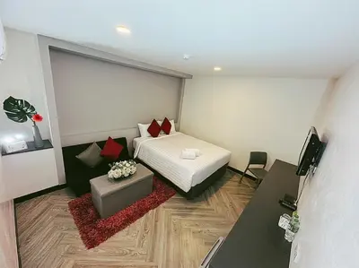a bedroom with a bed and a table and a tv at 14 Sathorn Hotel in Bangkok