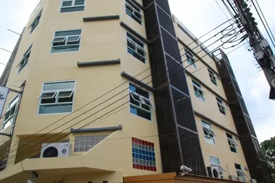 a tall yellow building with a lot of windows at Aubon Hostel in Bangkok